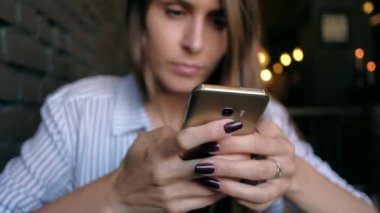 Smartphone kullanarak ve kafede kahve içme güzel kadın.