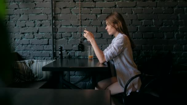 Hermosa mujer usando teléfono inteligente y beber café en la cafetería . — Vídeo de stock