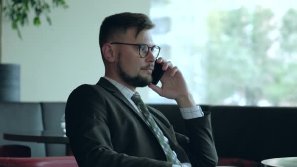 Hombre de negocios en la oficina hablando por teléfono. — Vídeo de stock