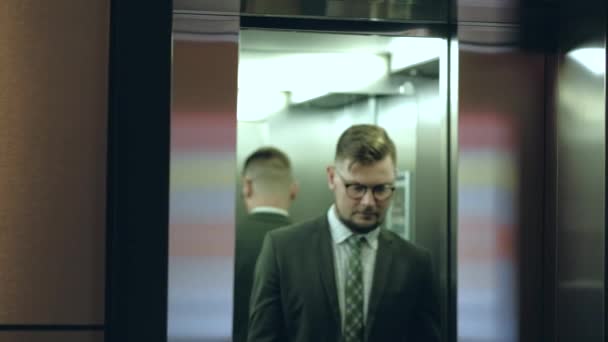 Zakenman in een pak met een stropdas uit de lift in het hotel. — Stockvideo