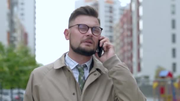彼の携帯電話を屋外で話して朗らかビジネスマン. — ストック動画