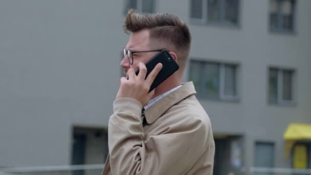 Hombre de negocios alegre hablando en su teléfono al aire libre . — Vídeos de Stock