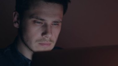 Adam geceleri dizüstü bilgisayarda çalışıyor..