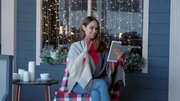 Die schöne Frau im Café nutzt ein digitales Tablet, um mit Freunden zu kommunizieren. Frohes neues Jahr. Weihnachtskonzept. — Stockvideo