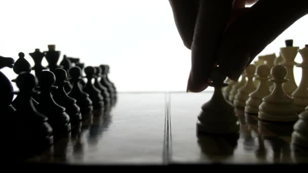Schachspiel, die Silhouettenfiguren auf weißem Hintergrund. — Stockvideo