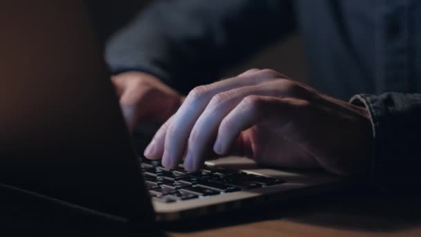 Las manos de un hombre que trabaja en el ordenador portátil por la noche . — Vídeos de Stock