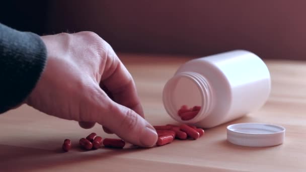 gros plan - main humaine prend la capsule rouge 