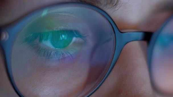 Extremo ojo de cerca de la mujer en gafas que trabajan en el ordenador portátil por la noche. 4k . — Vídeo de stock