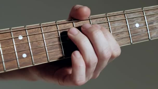 Primer plano guitarrista toca en la guitarra sobre fondo blanco . — Vídeos de Stock