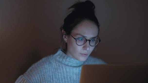 Aranyos nő, szemüveg, böngészés az interneten, sötét szobában. — Stock videók