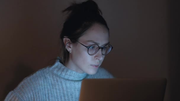 Aktiv kvinna frilansare arbetar nattetid på anteckningsboken. — Stockvideo