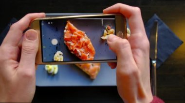 İştah açıcı yemek yanında smartphone restoranda fotoğraf çekme eller.
