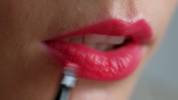 Das Mädchen schminkt sich auf den Lippen. roten Lippenstift auf die Lippen auftragen. Nahaufnahme. — Stockvideo