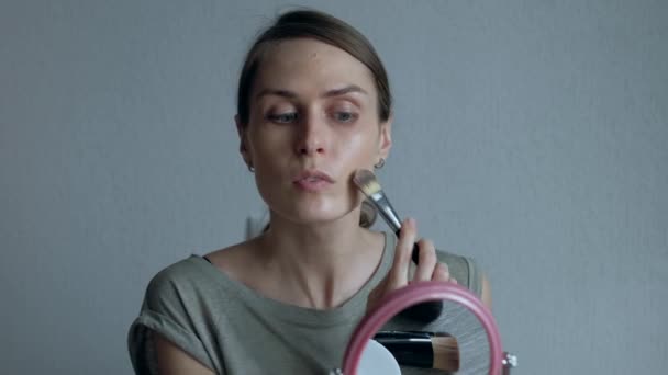 Žena, která dělá make-up na tvář před kulaté zrcadlo. — Stock video