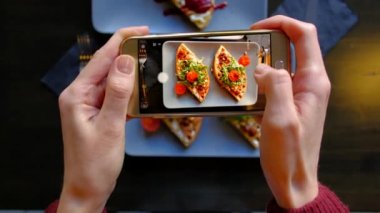 Kadının kullanma Smartphone almak fotoğraf, gıda önce yeme içinde Restoran eller