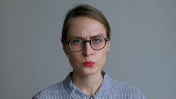 Rapariga zangada de óculos a apontar o dedo. sobre fundo branco . — Vídeo de Stock