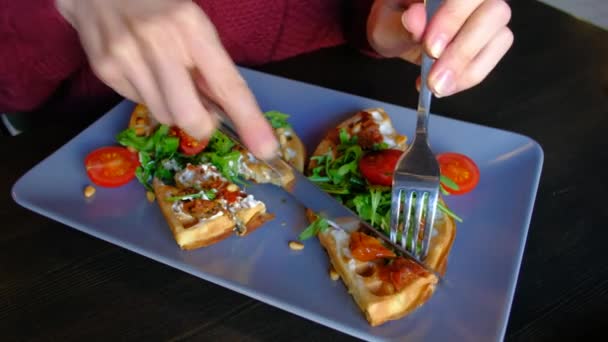 Close-up - vrouw eet de schotel wafels met spinazie, cherry tomaten in café. — Stockvideo