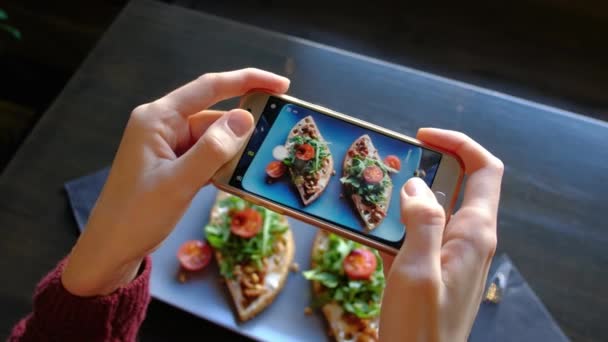 Mãos femininas fotografando comida apetitosa por smartphone no restaurante . — Vídeo de Stock