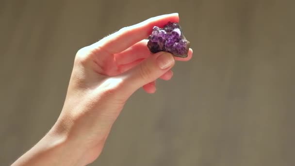 Руки женщины держат аметист драгоценного камня — стоковое видео