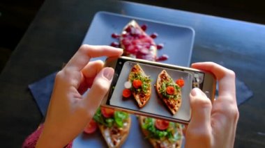 Kadının kullanma Smartphone almak fotoğraf, gıda önce yeme içinde Restoran eller