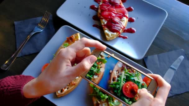 Frauenhände mit Smartphone fotografieren Essen vor dem Essen im Restaurant