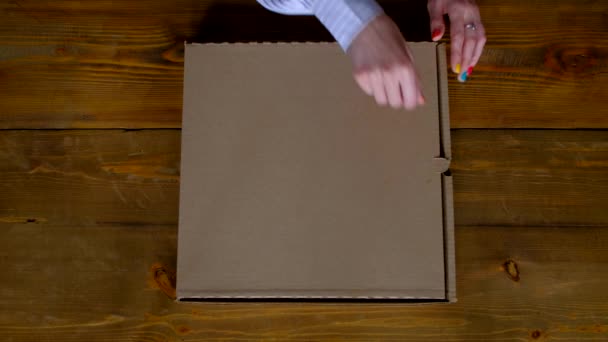 Ansicht von oben - Frau öffnet Schachtel mit Pizza. — Stockvideo