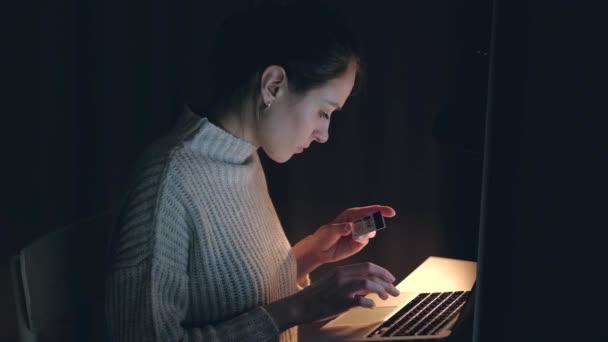Belle femme caucasienne utilisant un ordinateur portable achetant des achats en ligne par carte de crédit . — Video