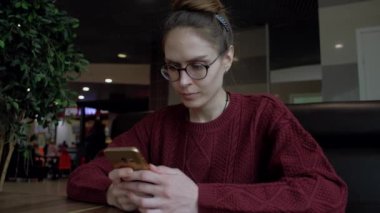 Sevimli erkek kafede Smartphone kullanarak.