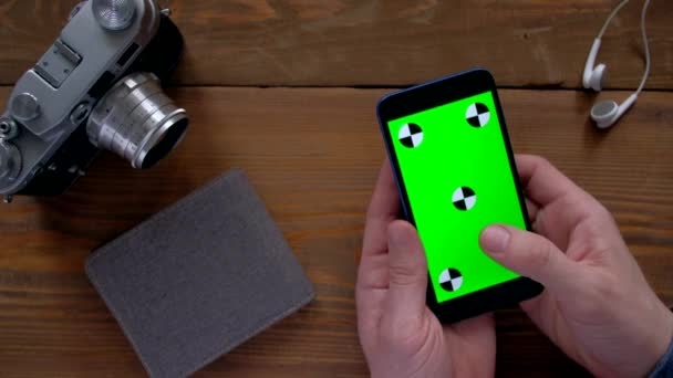 Maschio utilizzando smartphone con schermo verde su tavolo in legno . — Video Stock