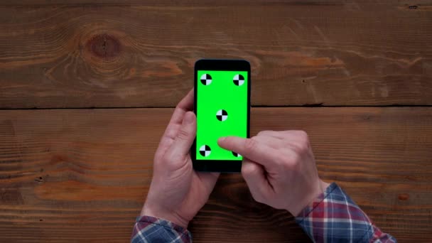 Uomo utilizzando smartphone con schermo verde su tavolo in legno . — Video Stock