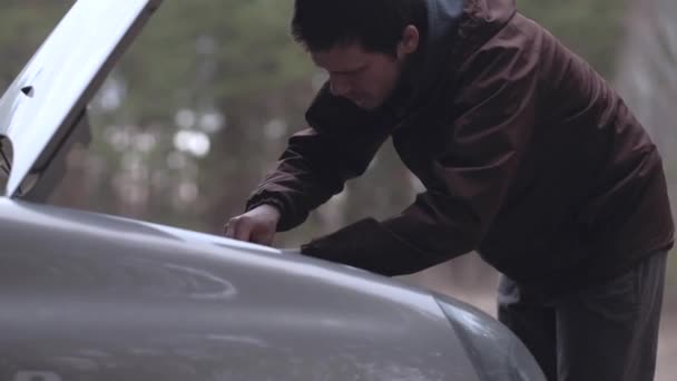 Крупним планом - чоловік ремонтує зламаний автомобіль . — стокове відео