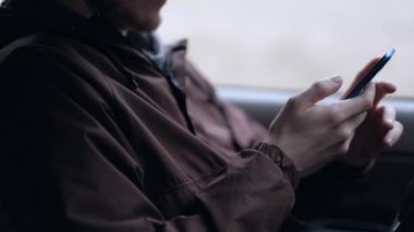 Genç bir adam akıllı telefon kullanmak, araba kabinde oturan.