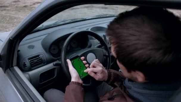 Manlig förare med hjälp av smartphone med grön skärm i bilen. — Stockvideo