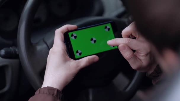 Mannelijke bestuurder met behulp van smartphone met groen scherm in de auto. — Stockvideo