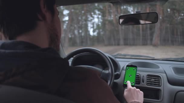 Genç bir adam akıllı telefon kullanmak, araba kabinde oturan. — Stok video