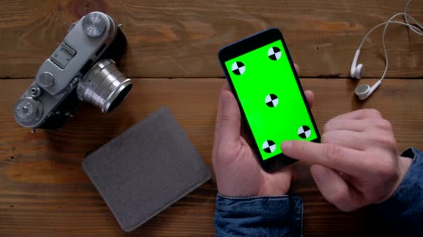 Male using smartphone  with green screen on wood table. — Stock Video