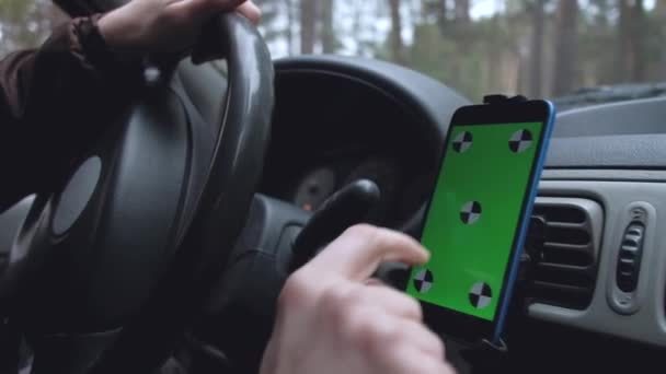 mains du conducteur en utilisant un smartphone avec écran vert sur la route .