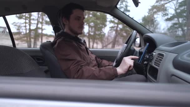 Hombre europeo uso de teléfono inteligente, sentado en la cabina del coche . — Vídeos de Stock