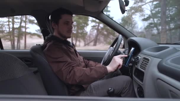 Homem europeu usa smartphone, sentado na cabine do carro . — Vídeo de Stock