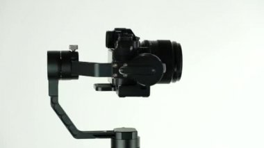 Dijital kamera ile elektronik stabilizatör beyaz arka planda döner.