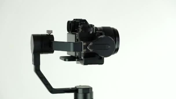 Elektronisk stabilisator med digitalkamera roterar på vit bakgrund. — Stockvideo