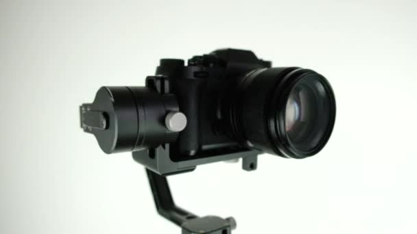 Gimbal with digital camera rotates on white background. — Stock Video