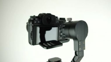 Dijital kamera ile elektronik Steadycam beyaz arka planda döner.