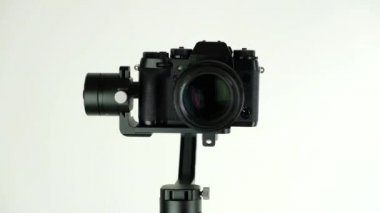 Dijital kamera ile elektronik Steadycam beyaz arka planda döner.