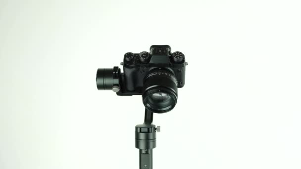 Gimbal with digital camera rotates on white background. — Stock Video