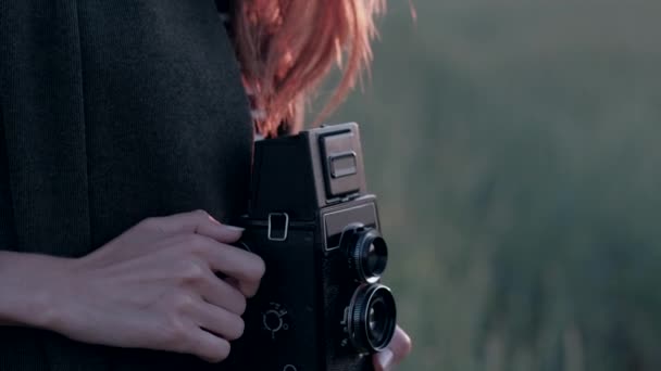 Vrouw met vintage camera op veld in zomer zacht. Close-up. — Stockvideo