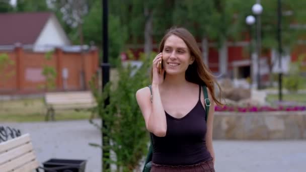 Chica morena hablando en el teléfono inteligente al aire libre . — Vídeos de Stock