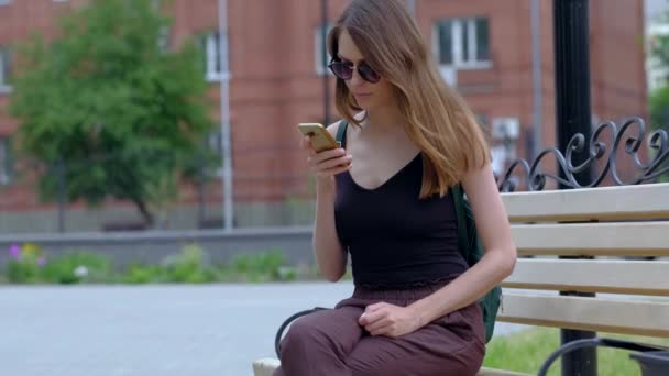 Flicka använda smartphone i utomhus. — Stockvideo