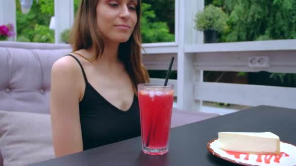 Kvinna sitter på terrassen dricker kall cocktail. — Stockvideo