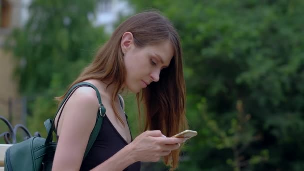 Chica utilizar el teléfono inteligente en el aire libre . — Vídeos de Stock